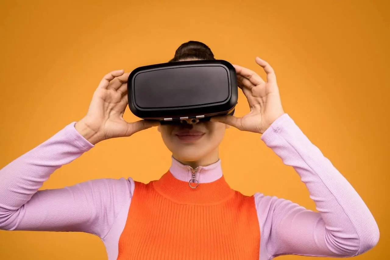 A woman holds a VR gadget to her face displaying potential of VR integration.