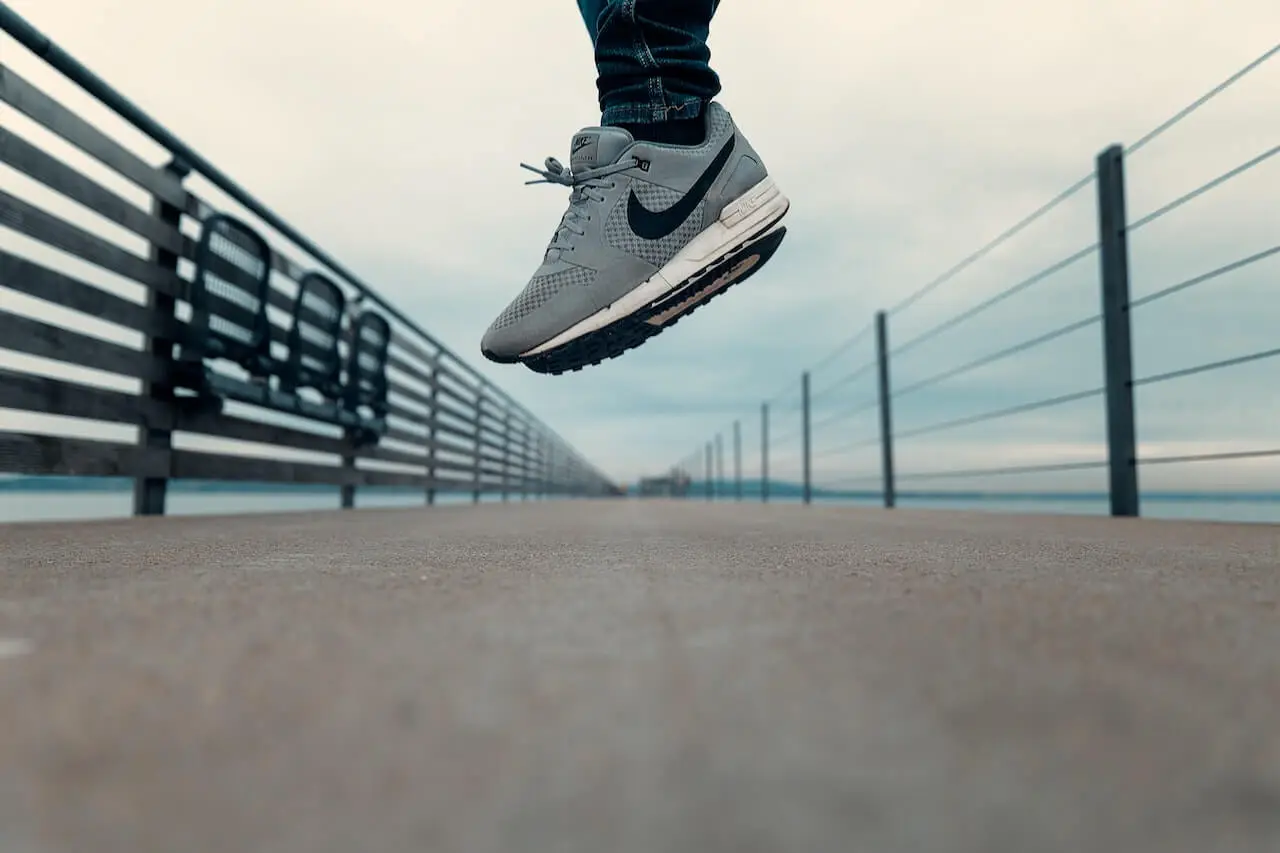 A person wearing grey Nike shoes jumps in mid-air used as an example of brand voice.
