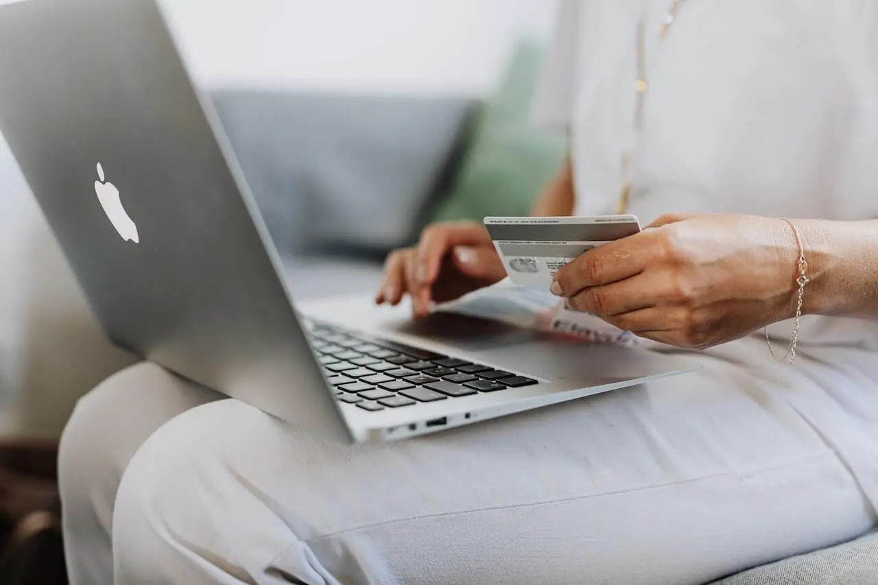 Woman on a laptop holding a credit card in a stage of customer journey.