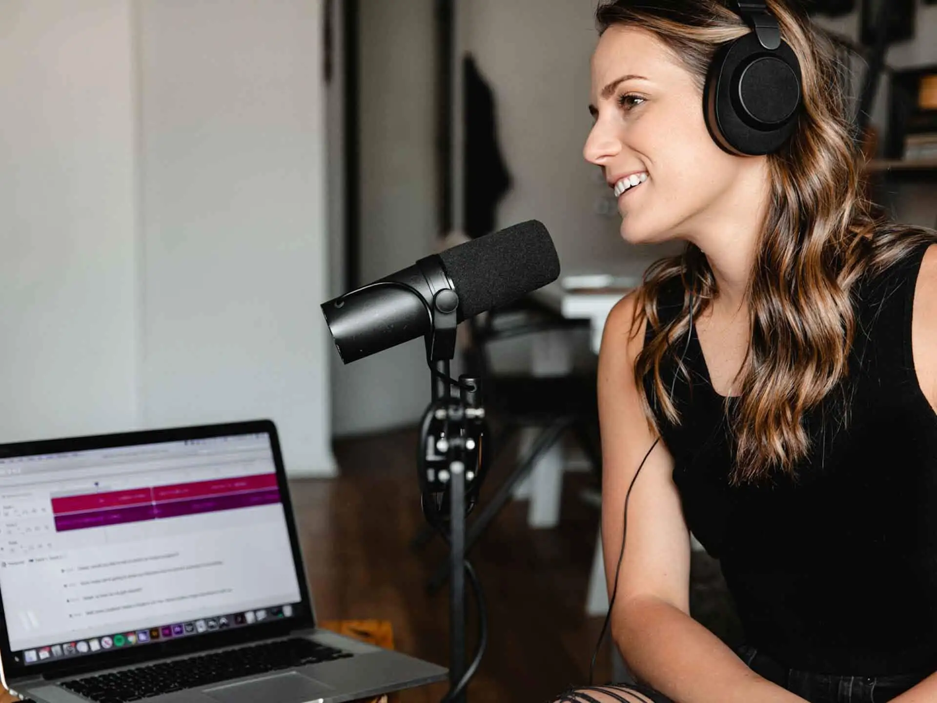 Woman sitting on chair in front of microphone for podcast recording